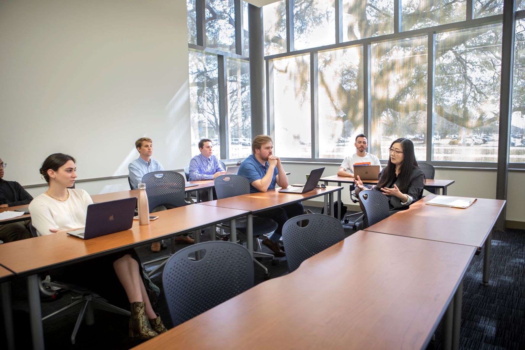 small classroom of studnets learning in front of large window