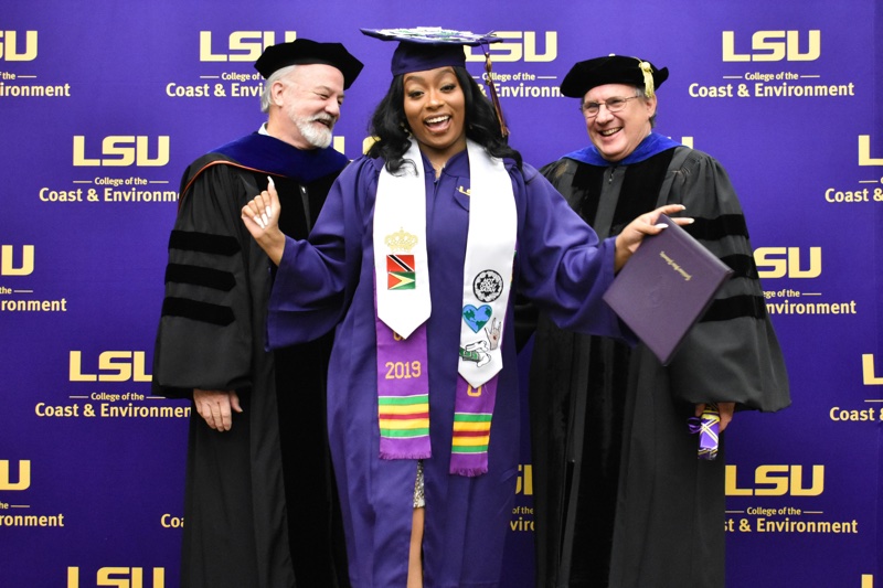 a woman in a cap and gown does a dance after recieving her diplomaholder Image