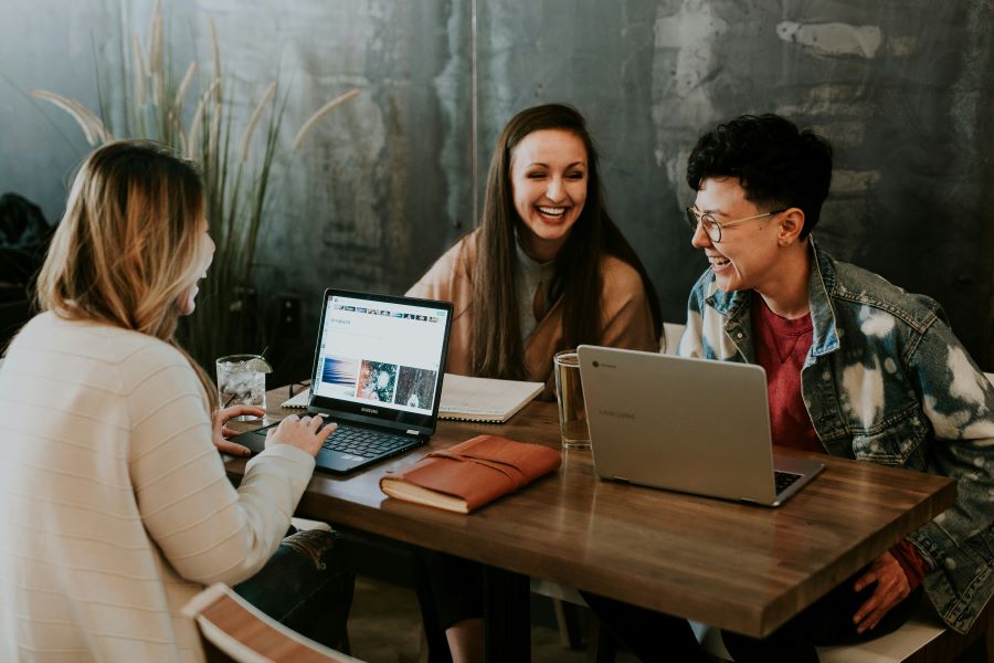 three students smile and study