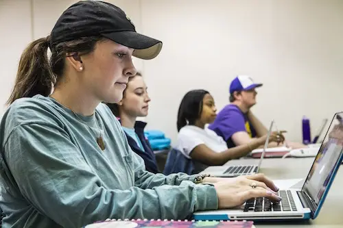 Student typing at a computer