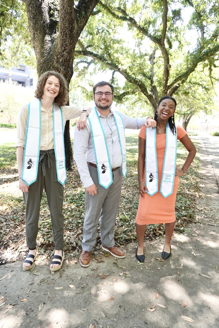 Three students posing for a graduation photo