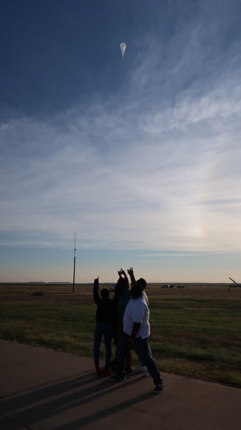 Students pointing to their payload flying on HASP 2022.